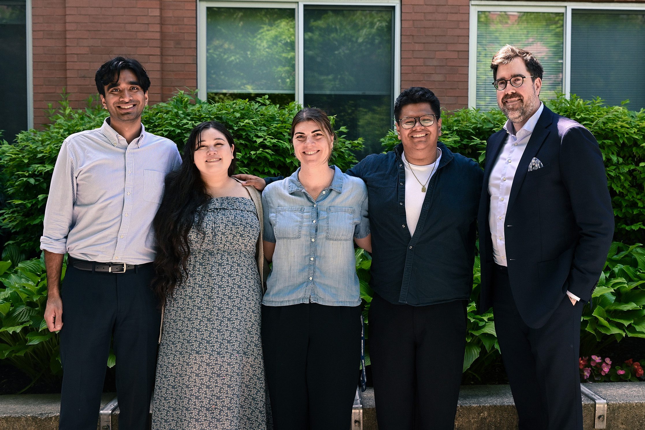 five staff members of the Dean of Students' Office team pose in front of Innis College
